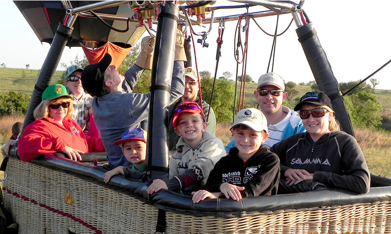 Excited passangers about to embark on a hot air ballooning adventure.